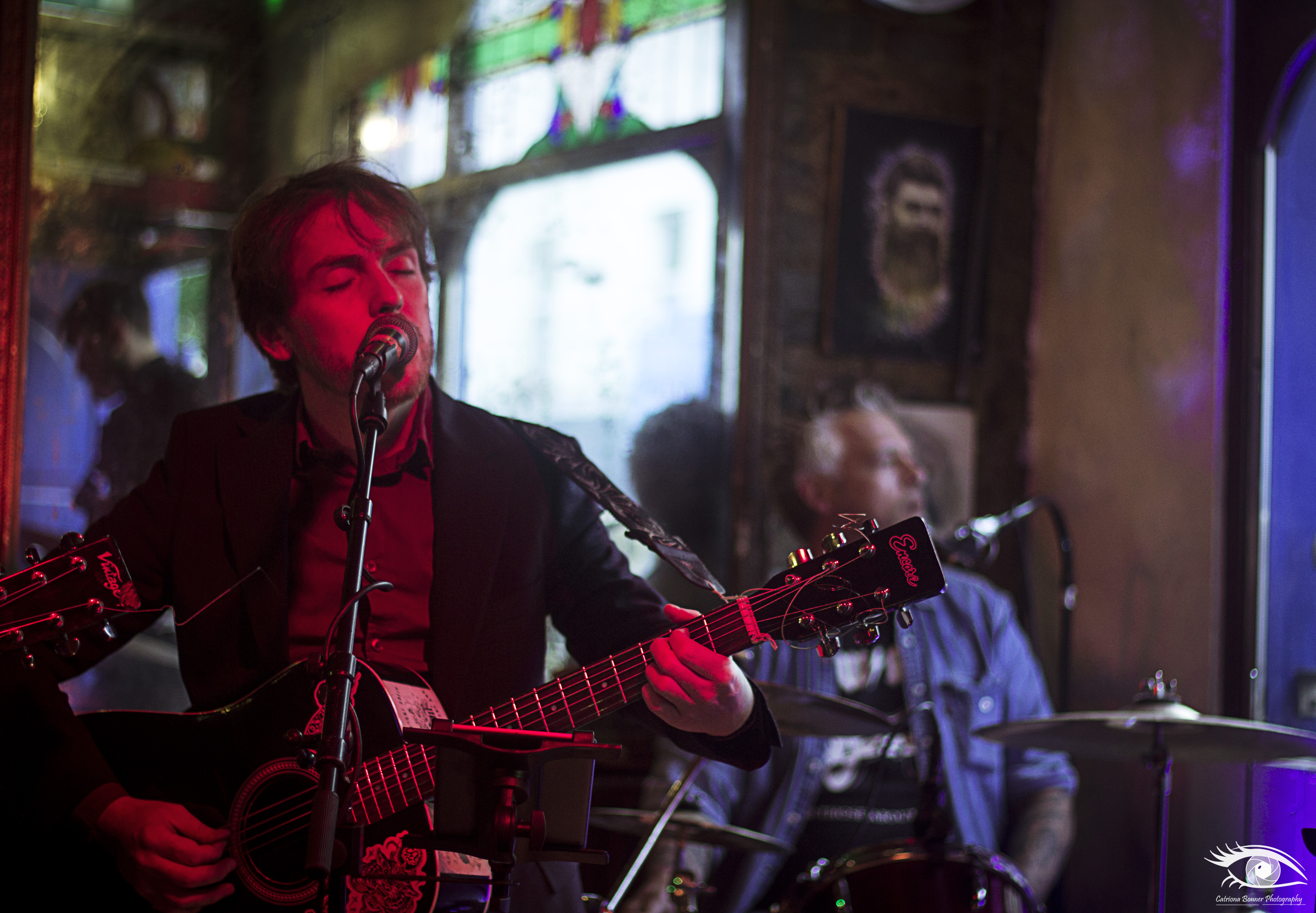 3 female figures stand looking forwards, shielding their eyes from the sun